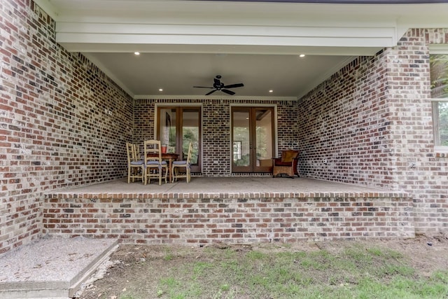 entrance to property with ceiling fan and a patio area