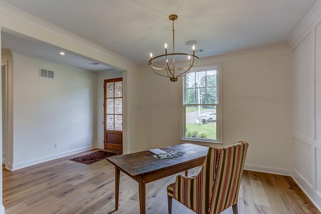 dining area featuring an inviting chandelier, light hardwood / wood-style floors, and ornamental molding