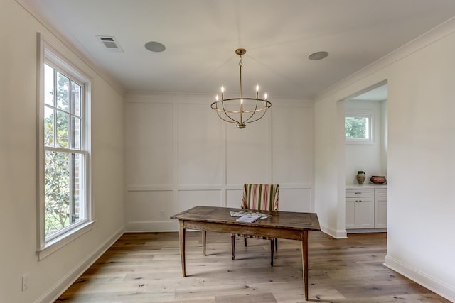 dining room featuring a notable chandelier, plenty of natural light, and light hardwood / wood-style floors