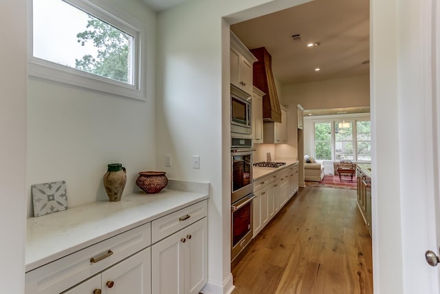 kitchen featuring white cabinets, light wood-type flooring, and stainless steel appliances