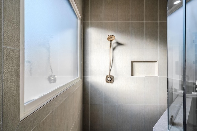 bathroom with walk in shower and tile walls