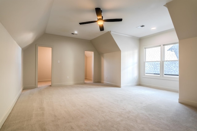 additional living space featuring ceiling fan, light colored carpet, and vaulted ceiling