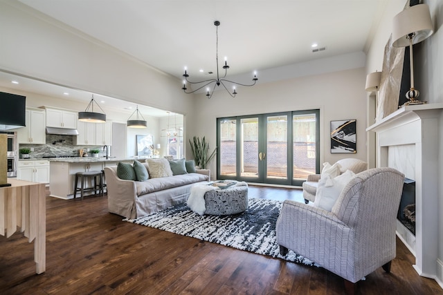 living room featuring french doors, dark hardwood / wood-style floors, and a notable chandelier