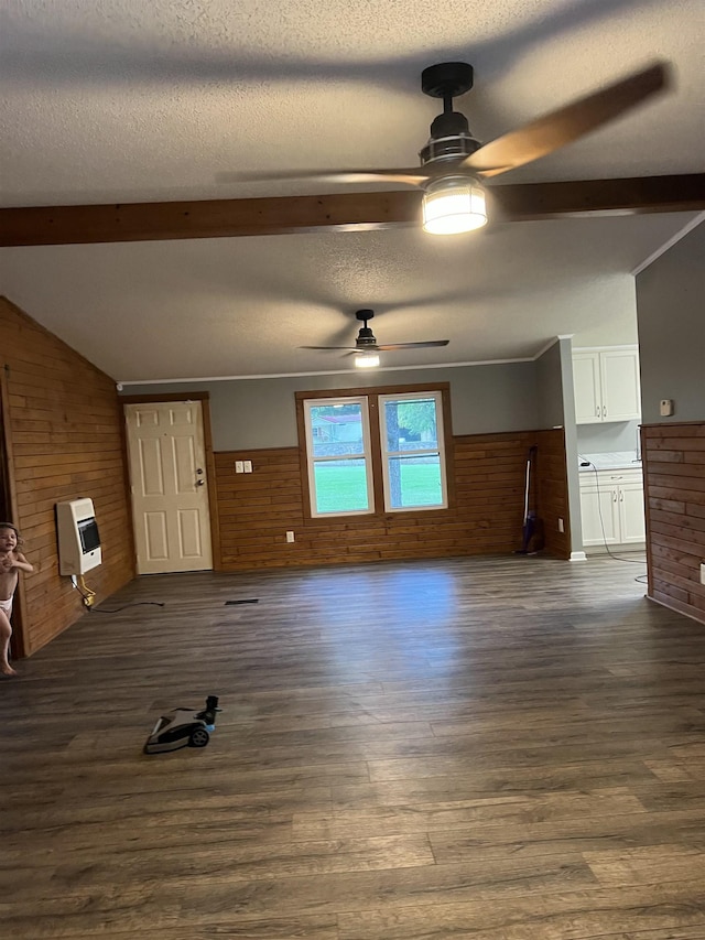 unfurnished living room featuring heating unit, wooden walls, ceiling fan, and dark hardwood / wood-style floors