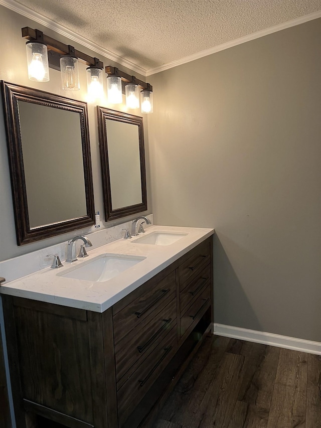 bathroom featuring crown molding, hardwood / wood-style floors, vanity, and a textured ceiling