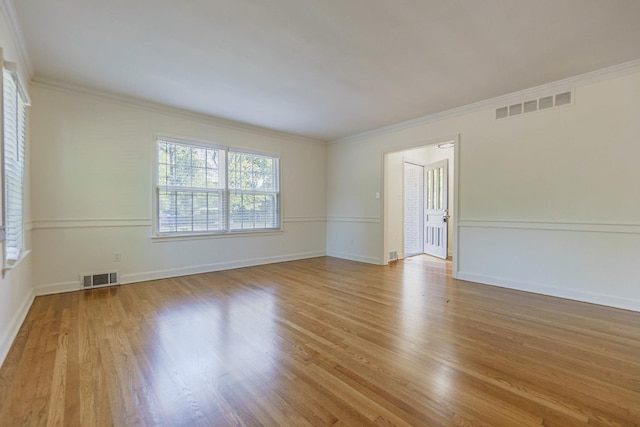 unfurnished room with visible vents, crown molding, and light wood-style flooring