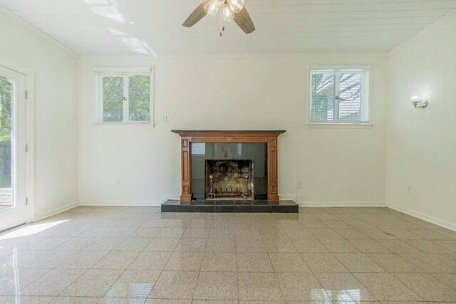 unfurnished living room with crown molding, a healthy amount of sunlight, and baseboards