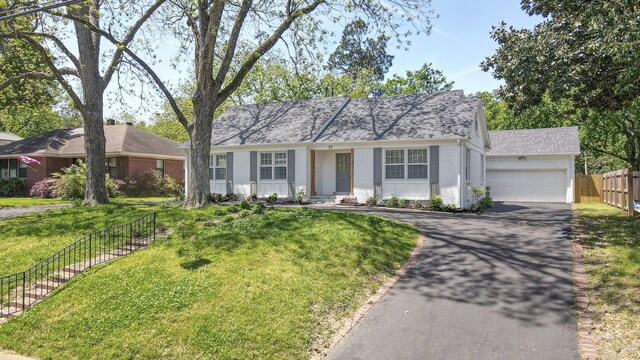 single story home featuring brick siding, a shingled roof, an attached garage, driveway, and a front lawn