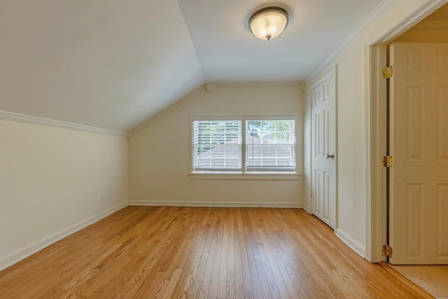 additional living space featuring light wood-type flooring, baseboards, and lofted ceiling