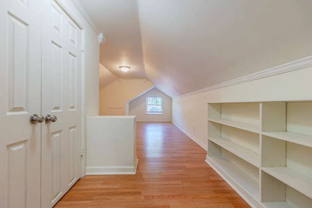 bonus room with vaulted ceiling, light wood-style flooring, and baseboards