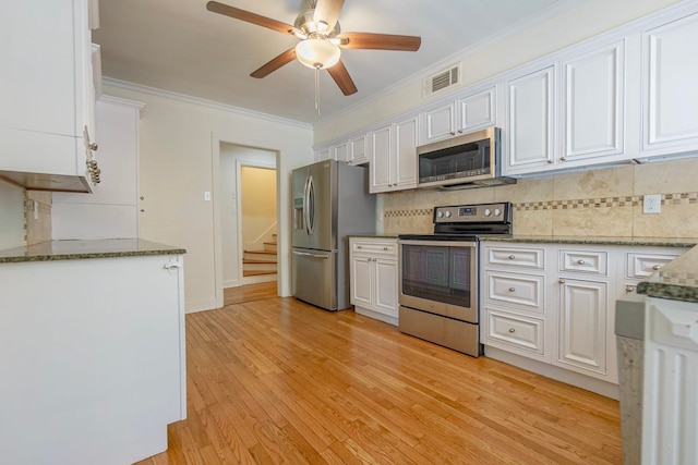 kitchen featuring crown molding, visible vents, decorative backsplash, appliances with stainless steel finishes, and white cabinets