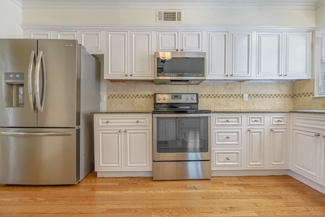 kitchen featuring stainless steel appliances, light wood finished floors, visible vents, and white cabinets