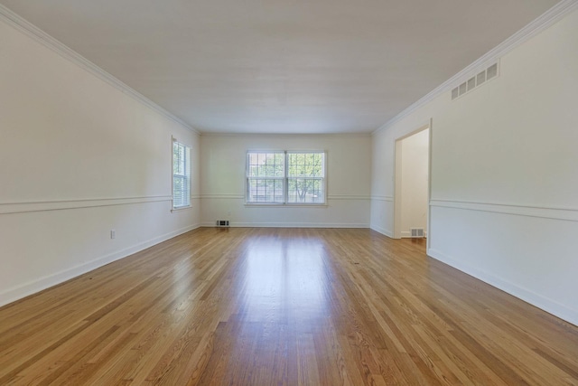 unfurnished room featuring ornamental molding, baseboards, visible vents, and light wood finished floors