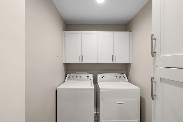 laundry room with washer and dryer and cabinets