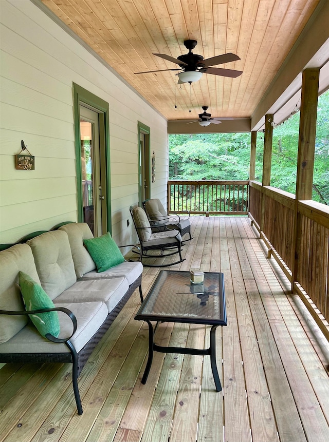 wooden deck with ceiling fan and outdoor lounge area