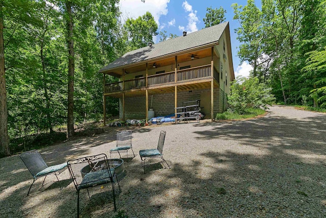 rear view of property with a fire pit, a balcony, and a patio area