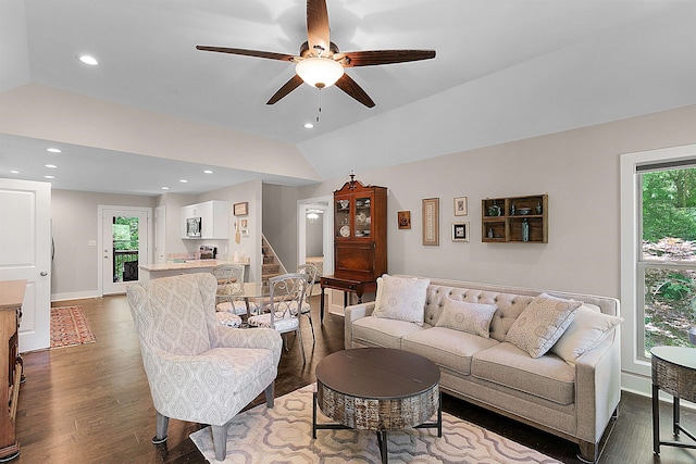 living room featuring a fireplace, ceiling fan, vaulted ceiling, and dark hardwood / wood-style floors