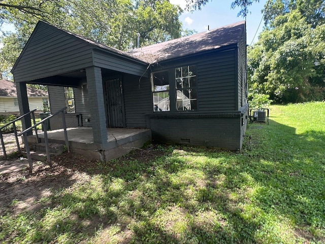 exterior space featuring central AC and a front lawn