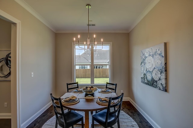 dining room with crown molding, dark wood-type flooring, and a chandelier