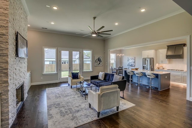 living room with a fireplace, ornamental molding, and dark hardwood / wood-style flooring