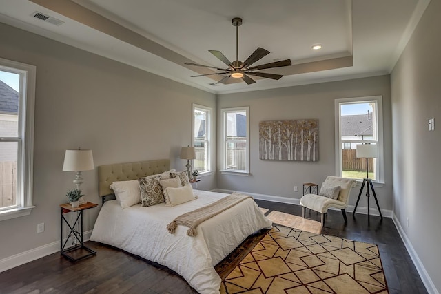 bedroom with dark hardwood / wood-style flooring, crown molding, a raised ceiling, and ceiling fan