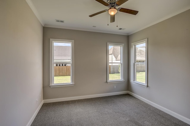 carpeted spare room featuring crown molding, ceiling fan, and a healthy amount of sunlight