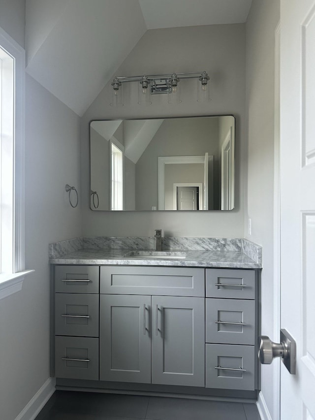 bathroom with vanity and lofted ceiling