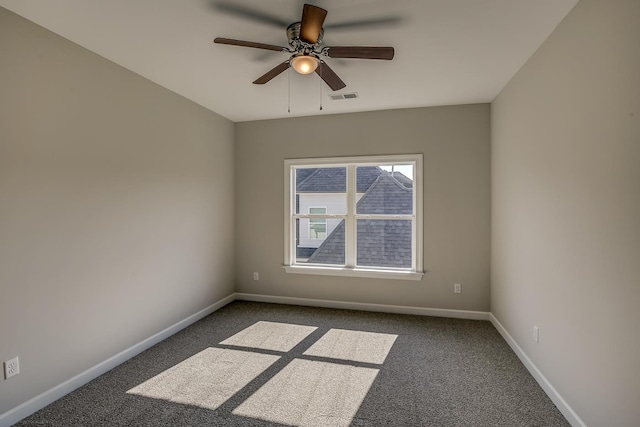 spare room with dark colored carpet and ceiling fan