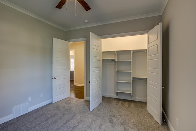 unfurnished bedroom with ornamental molding, light colored carpet, ceiling fan, and a closet