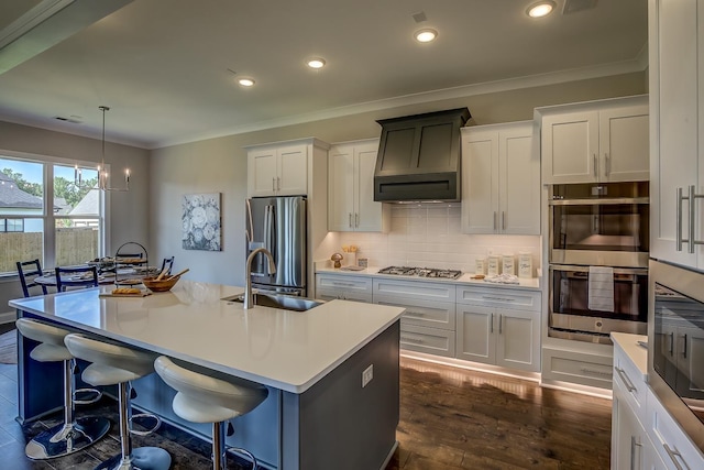 kitchen with sink, decorative light fixtures, a center island with sink, appliances with stainless steel finishes, and white cabinets