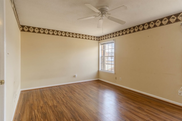 empty room with ceiling fan, a textured ceiling, and dark hardwood / wood-style flooring