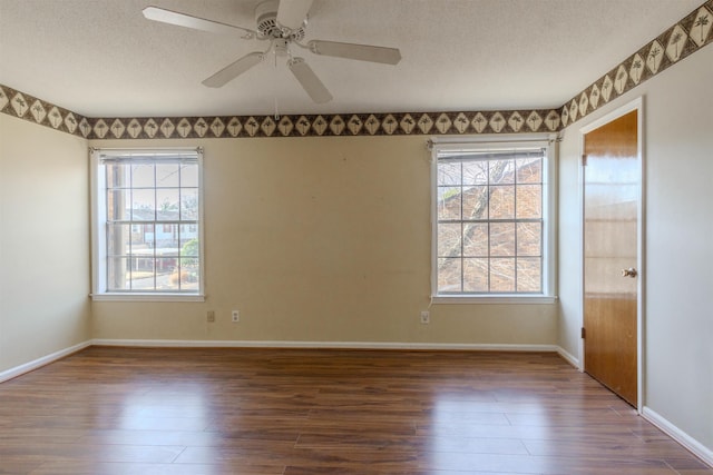 spare room with a textured ceiling, ceiling fan, and dark hardwood / wood-style floors