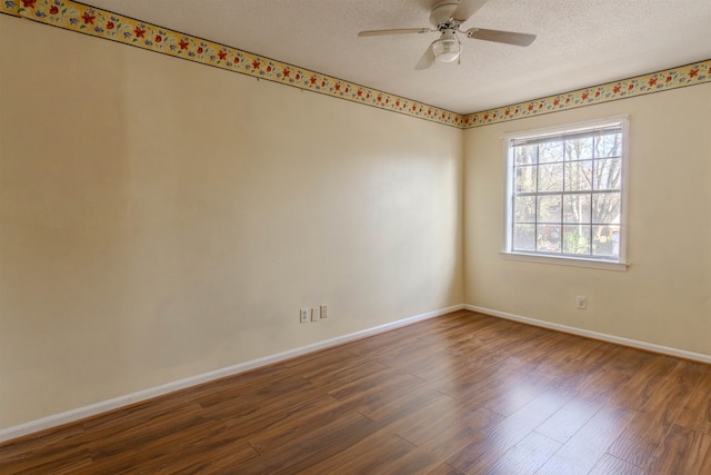 spare room featuring ceiling fan, dark wood-type flooring, and a textured ceiling