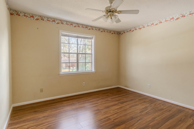 unfurnished room with ceiling fan and dark wood-type flooring