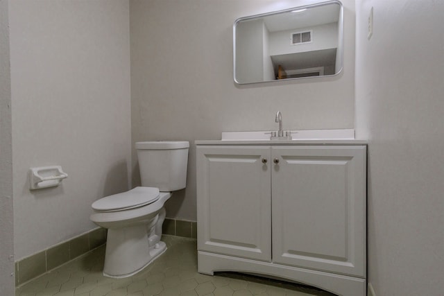 bathroom with toilet, tile flooring, and vanity