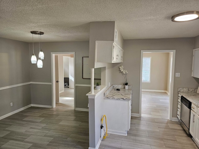 kitchen with white cabinets, pendant lighting, dishwasher, and light stone counters