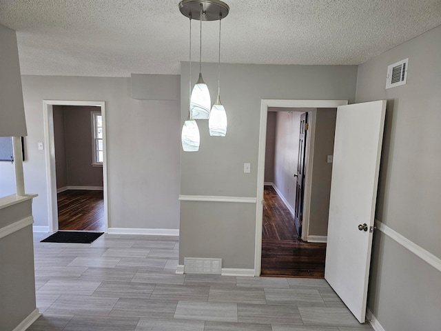 tiled spare room with a textured ceiling