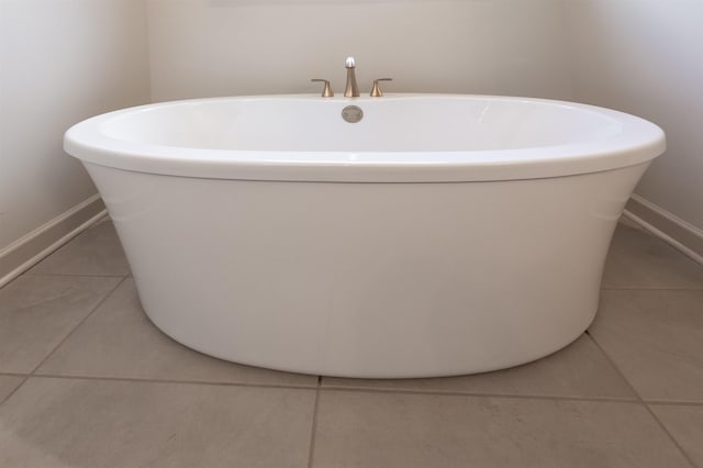 bathroom with tile patterned flooring and a bath