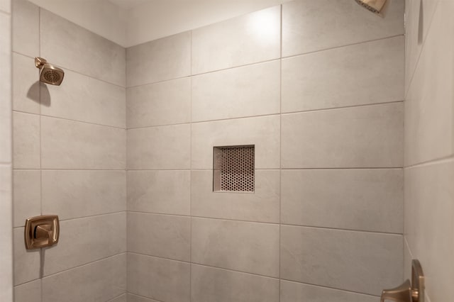 interior details with a tile shower