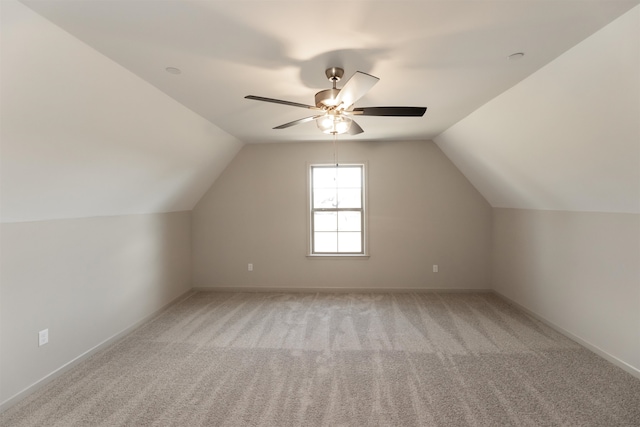 bonus room with vaulted ceiling, light colored carpet, and ceiling fan