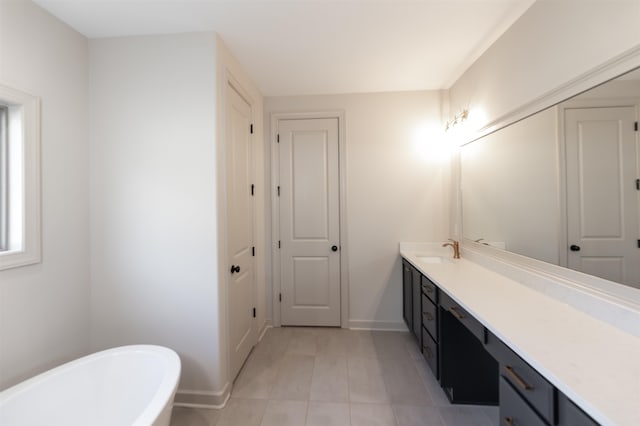 bathroom with vanity, tile patterned floors, and a tub to relax in