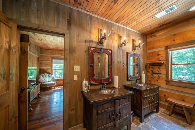 bathroom featuring a healthy amount of sunlight, wood walls, and wooden ceiling