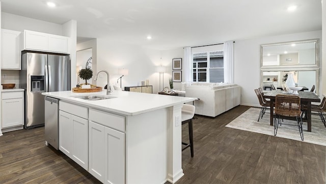 kitchen with a center island with sink, dark wood-type flooring, white cabinetry, and sink