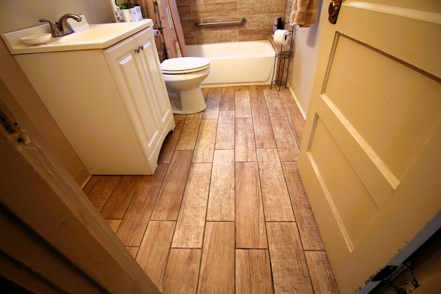 bathroom with hardwood / wood-style flooring, vanity, and toilet