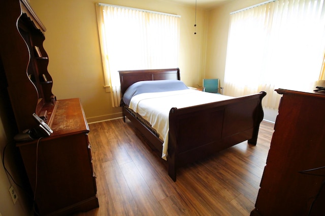 bedroom with dark hardwood / wood-style flooring