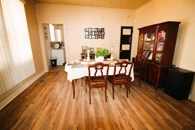 dining space with crown molding and wood-type flooring