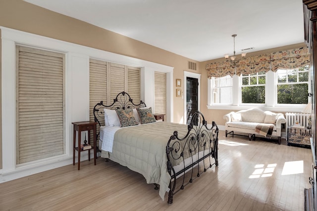 bedroom featuring a chandelier and light wood-type flooring