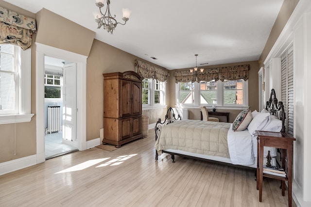 bedroom with an inviting chandelier, radiator, and light wood-type flooring