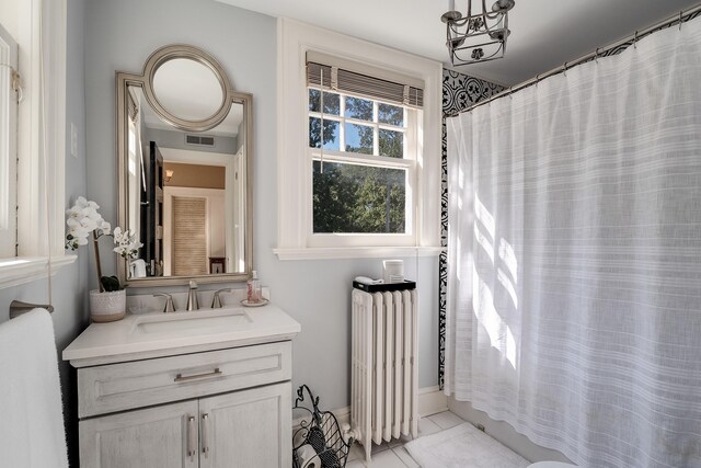 bathroom featuring radiator heating unit, vanity with extensive cabinet space, and tile flooring