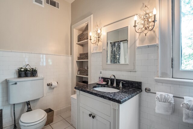 bathroom with tile walls, toilet, large vanity, and tile flooring